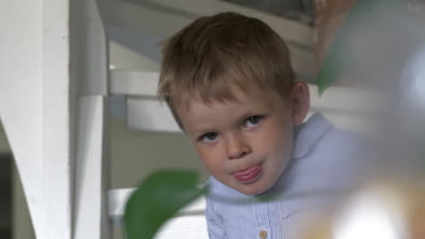 cute young caucasian boy looking at camera, stairs background