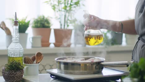 woman pouring oil to pan with veal shank