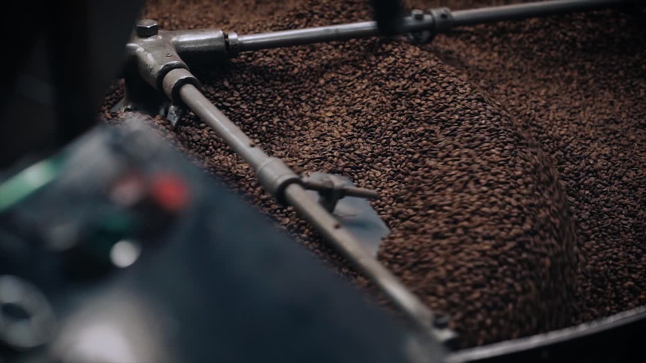 Coffee Roasting Process - Coffee beans in large roasting machine and machine detail.