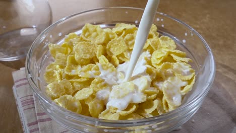 Crispy-yellow-corn-flakes-into-the-bowl-for-the-morning-a-delicious-Breakfast-with-milk.-Slow-motion-with-rotation-tracking-shot.