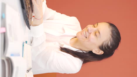 Vertical-video-of-Woman-looking-at-laptop-is-happy-and-dancing.