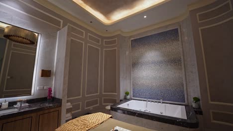 een filmische b-roll opname vangt een serene luxe massage kamer, versierd met zachte verlichting, pluche bedden, en een rustige sfeer.