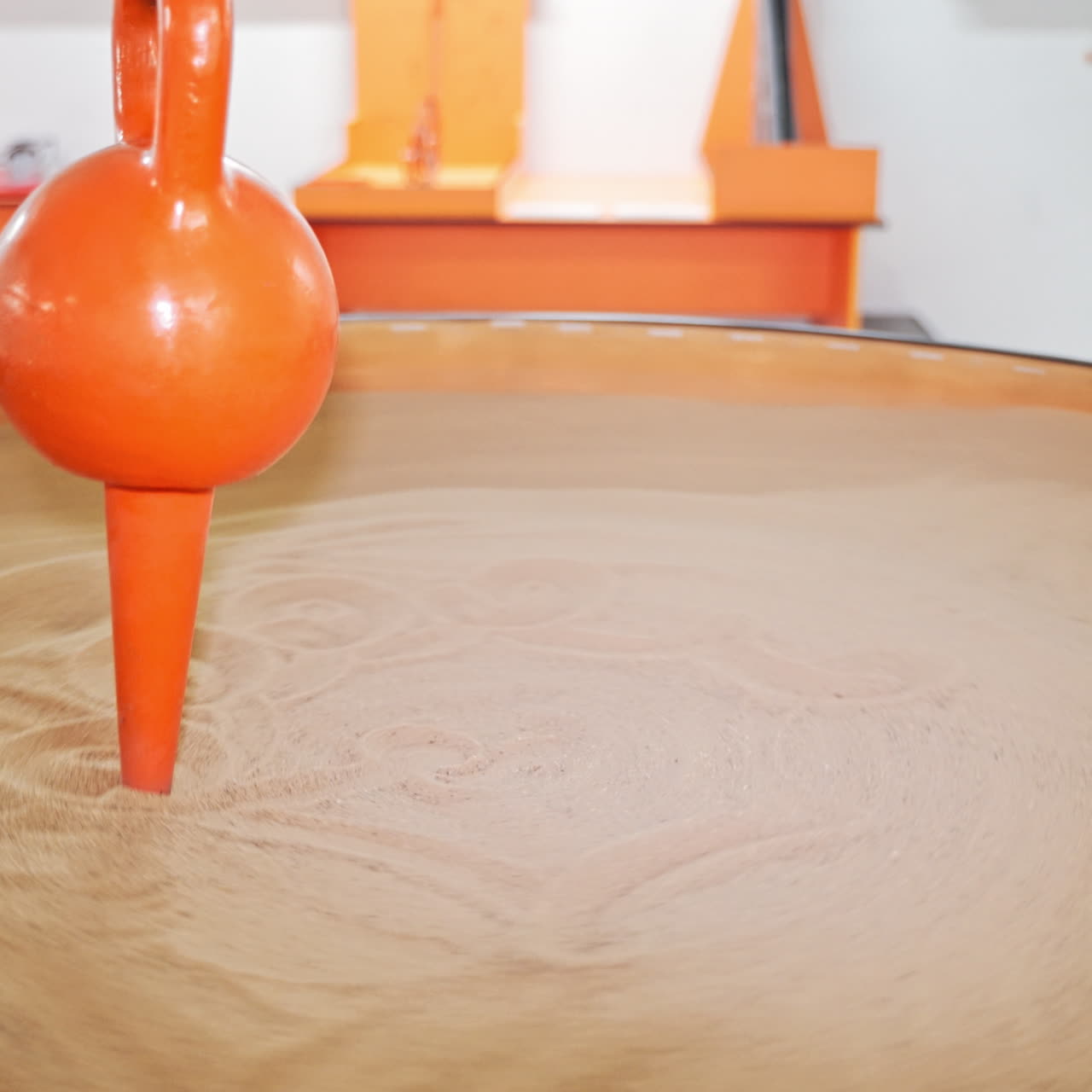 a little boy visiting a science museum for children. He plays with a sand pendulum