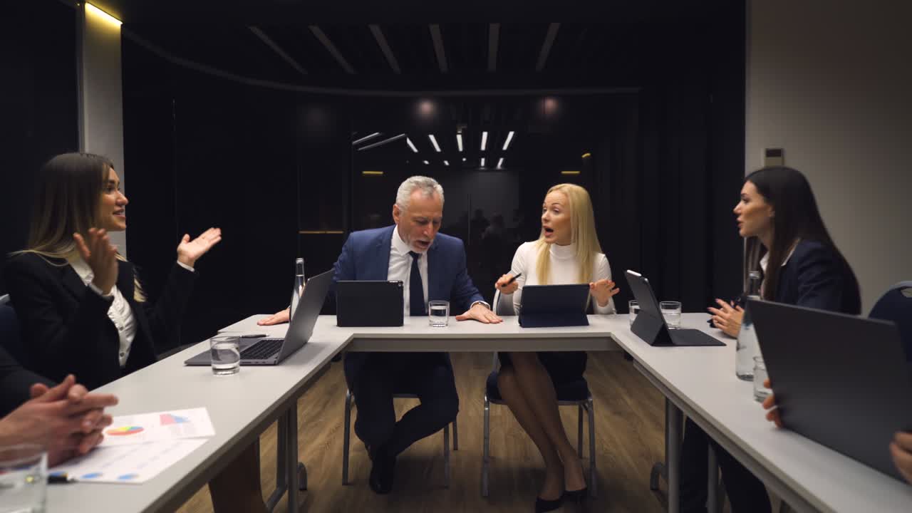 The business people sitting at the table and discuss emotionally