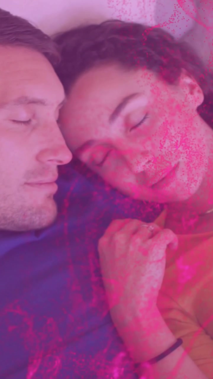 Vídeo vertical: Casal deitado na cama, terceiro quadro iniciando névoa rosa sobre os rostos, promovendo saúde.