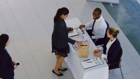 mujer de negocios registrándose en la mesa de registro de la conferencia 4k