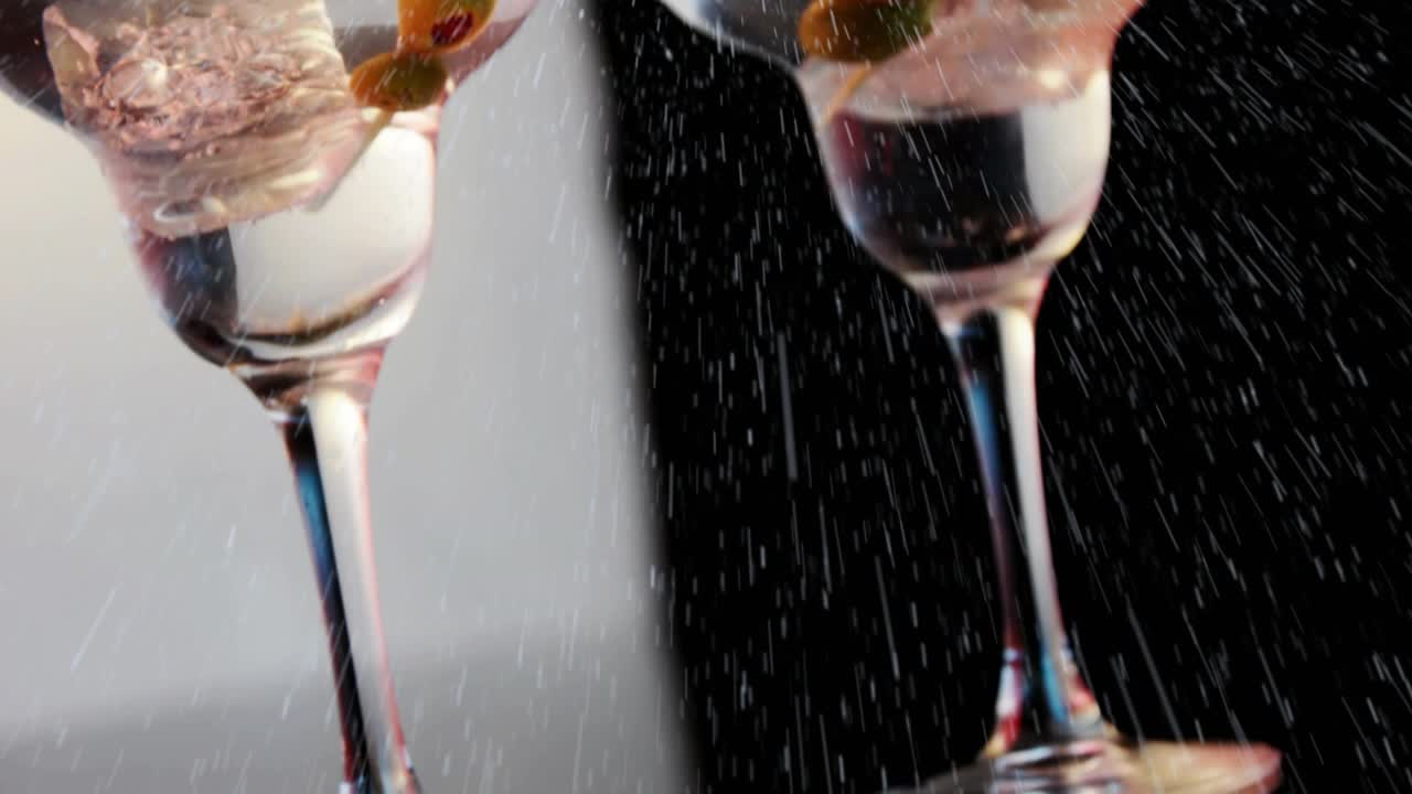 Spray starting between two cocktail glasses, droplets forming streaks, showing split tone contrast