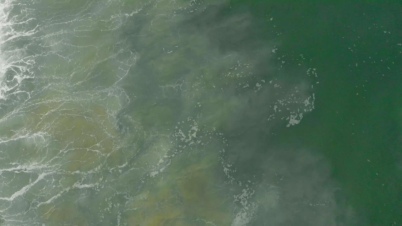 Riprese aeree dall'alto in 4K di onde enormi che si infrangono sulle spiagge di Varkala al mattino