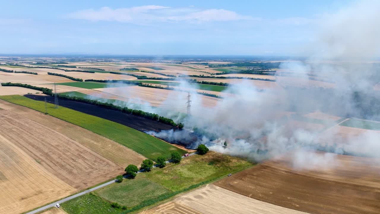 Panoramablick auf brennendes Getreidefeld mit Rauch – Drohnenaufnahme.