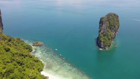 famous limestone cliff in ocean with coral reefs and clear water, koh poda, krabi