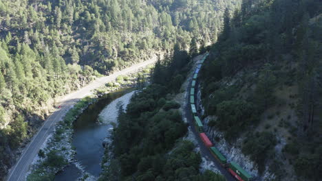 antena de un valle con el paso del ferrocarril union pacific, gran tren de carga que viaja a través del desfiladero, después del disparo de un dron