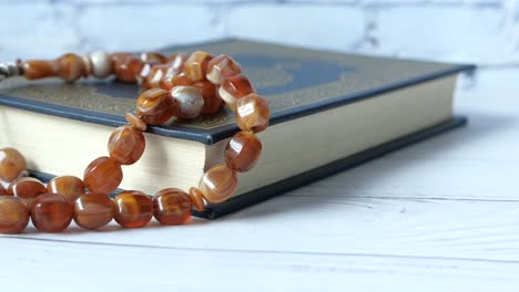 libro sagrado del corán, cuentas de oración en el fondo de madera