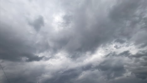 Dull grey cloudscape covering the horizon. Low angle view on the dark clouds accumulating in the sky. Timelapse.