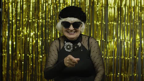 Senior-old-woman-in-stylish-sunglasses-pointing-finger-to-camera,-looking-happy,-choosing-person