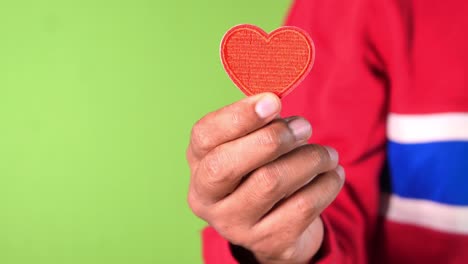 mano con un corazón rojo