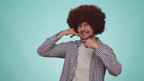 Cheerful-one-man-in-shirt-looking-at-camera-doing-phone-gesture-like-says-hey-you-call-me-back