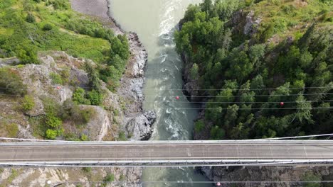 4k vertical top down view of cars driving across hagwilget canyon bridge in northern british columbia