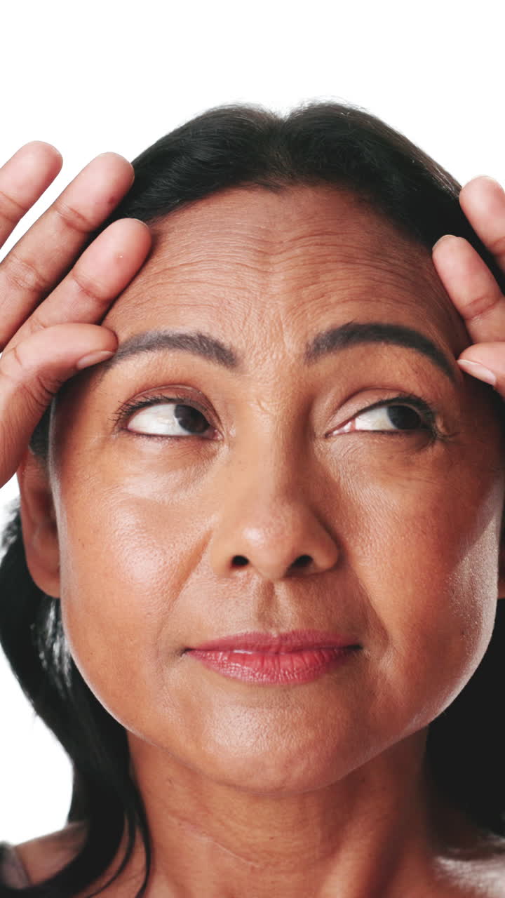 Close-up of Mature Woman Examining Forehead Wrinkles