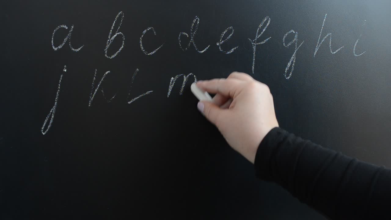 We write the alphabet on a board. We write with chalk on a board