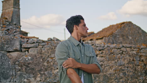 serious man looking distance at wall closeup. worker rolling up sleeves vertical