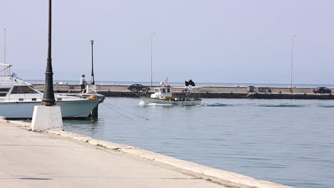 fishing boat is approaching the harbor, greece thessaloniki