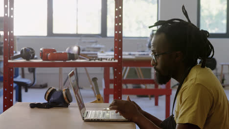 carpenter using laptop at workshop 4k