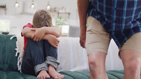 Caucasian-grandfather-and-grandson-sitting-on-sofa,-embracing-and-cheering-up,-slow-motion