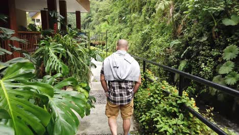 man walking through a lush garden