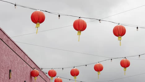 varias luces de linternas chinas colgando debajo de un día nublado