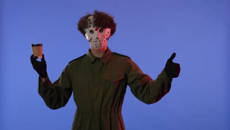 person in jason mask with coffee gesturing