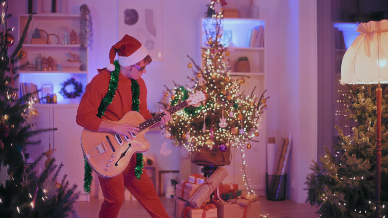 hombre tocando la guitarra en una casa iluminada durante la navidad