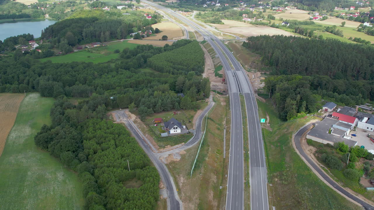 숲 나무와 호수와 폴란드의 시골 지역에서 빈 고속도로의 오름차순 공중 샷