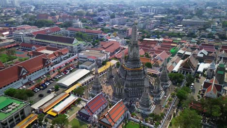 aerial medium orbit of wat arun temple in bangkok, thailand, with tall prang structures and scenic riverside location, establishing