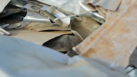 panning shot of crumpled metal sheets in a scrapyard