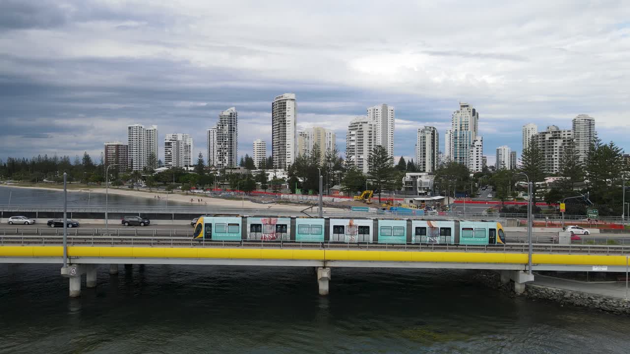 vista aérea en movimiento de un concurrido puente de carretera que cruza una popular vía fluvial con el horizonte de la ciudad al fondo