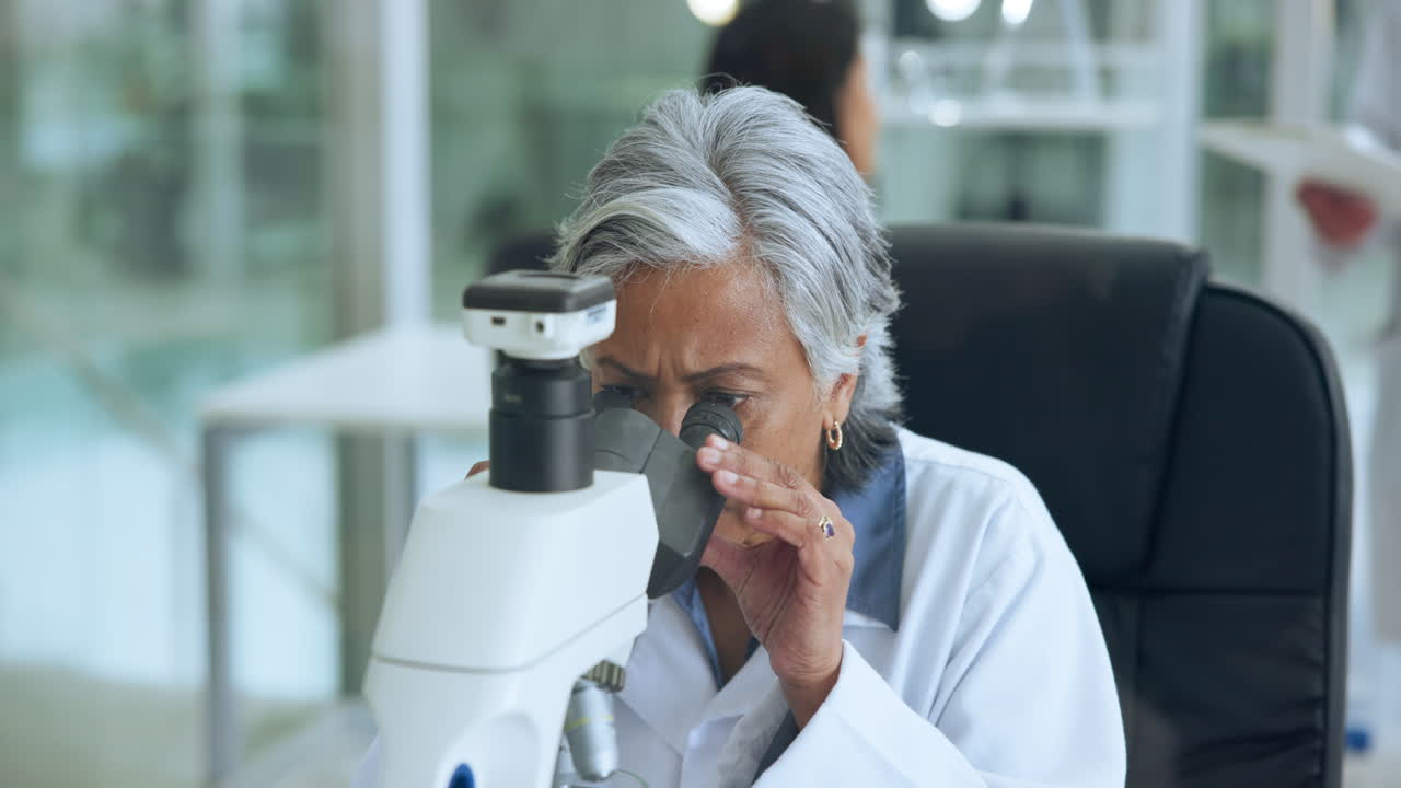 Scienziata anziana che lavora con il microscopio in laboratorio