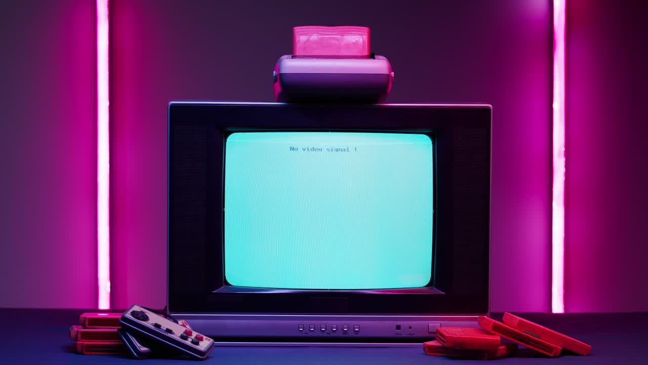 Old television with blue screen on pink neon background. Close-up of vintage tv and cartridges for retro playstation. Antique video game, nostalgia