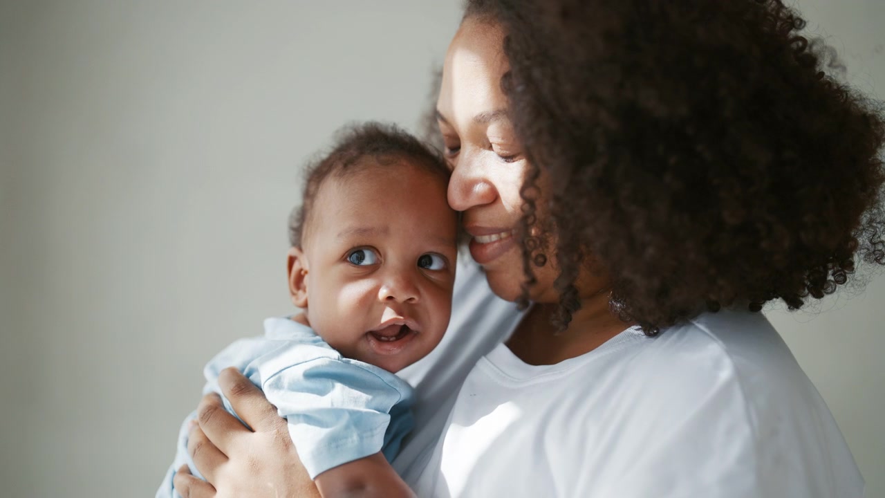 Mãe amorosa segurando seu filho bebê sob luz natural