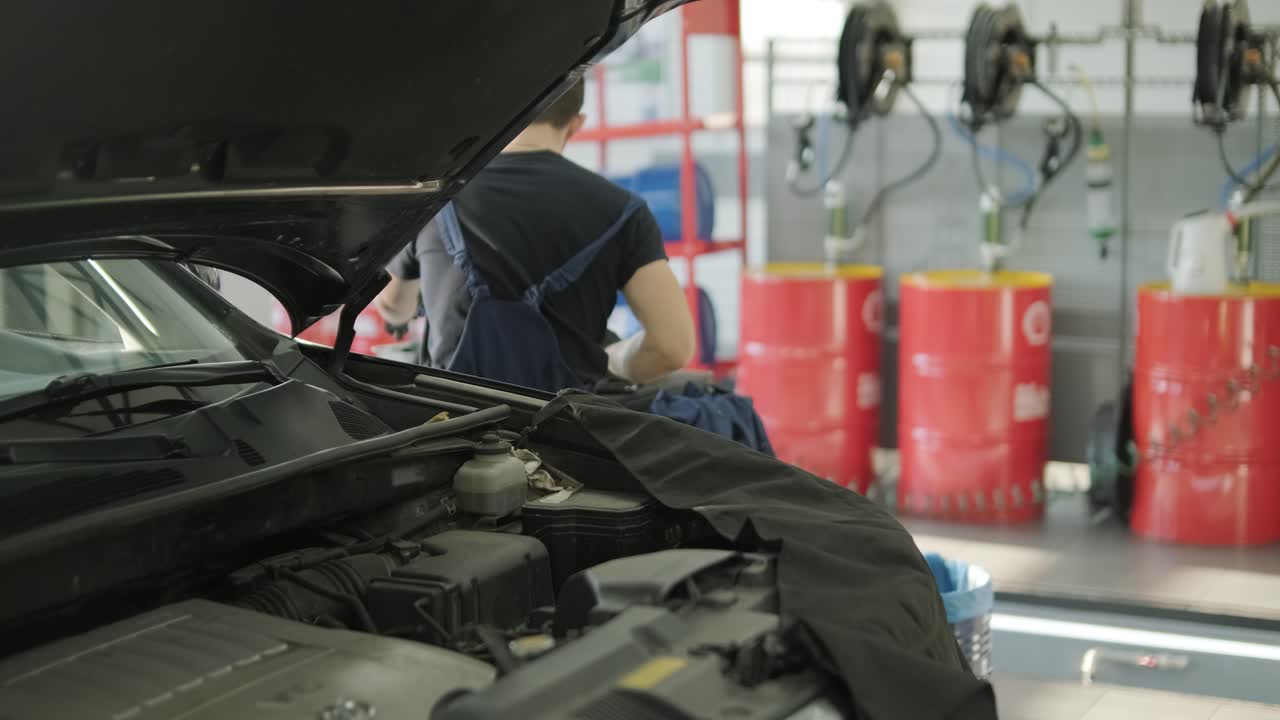mecánico de automóviles inspeccionando el motor del automóvil en el taller