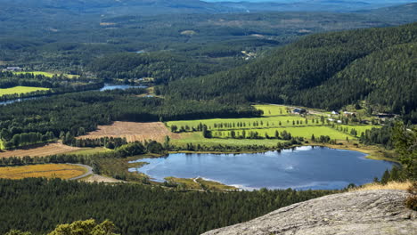 Tiro-De-Lapso-De-Tiempo-De-Sombras-De-Nubes-Moviéndose-Sobre-Un-Estanque,-Campos-Y-Bosques,-En-Lo-Alto-De-Una-Montaña,-Día-Soleado,-En-El-Sur-De-Noruega