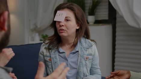 mixed race friends socializing during entertainment party while playing guess who game