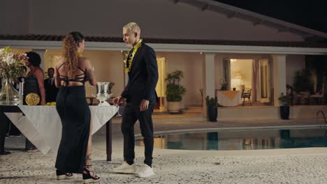people mingling at an elegant poolside night party