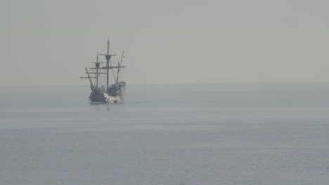 Ferdinand-Magallanes-Nao-Victoria-Carrack-Réplica-De-Barco-Con-Bandera-Española-Navega-En-El-Mediterráneo-Al-Amanecer-En-Mar-Tranquilo-Saliendo-Del-Marco-En-Cámara-Lenta-60fps