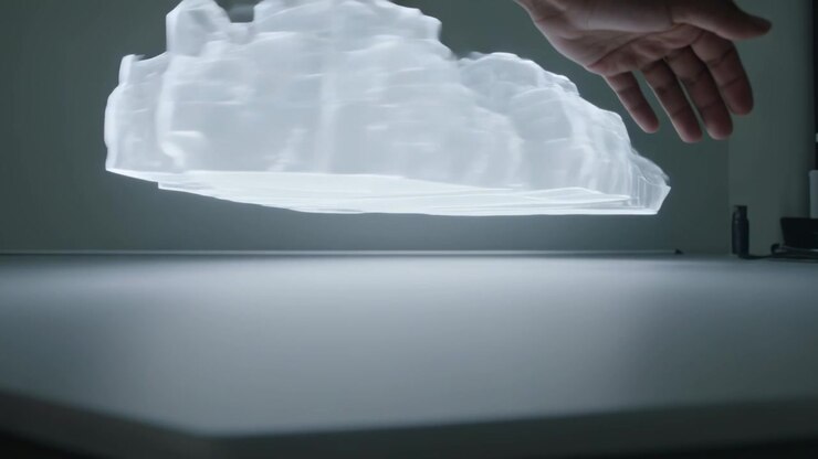Un braccio e una mano nudi si estendono in alto a sinistra, scorrendo sotto un modello 3D su un tavolo luminoso, tracciando i contorni.