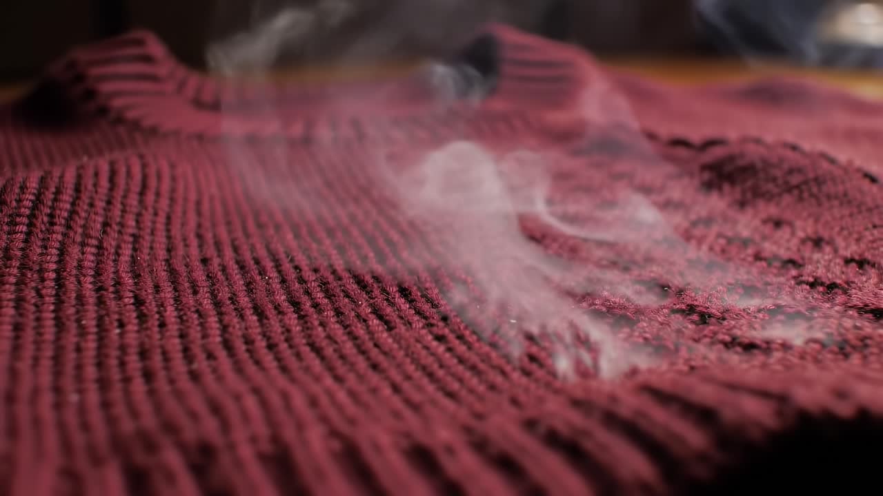 Close-up of a Maroon Sweater with Rising Steam, Capturing the Texture and Details of the Fabric in a Cozy Atmosphere