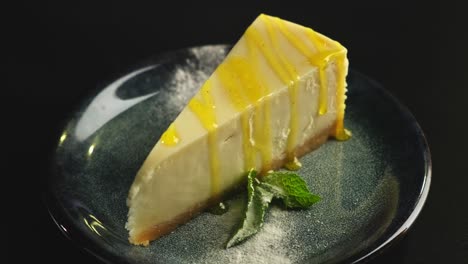 a piece of lemon sweet dessert on a plate on a black background.