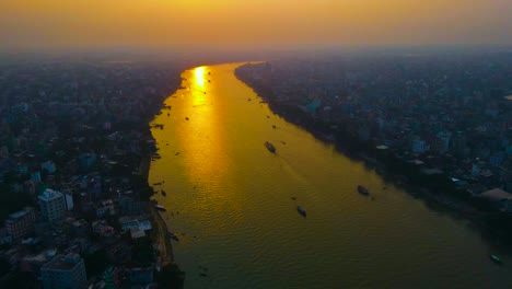 Aerial-cityscape-with-sunlight-reflecting-on-Buriganga-river-at-sunset-in-historical-Asian-city---Dhaka,-Bangladesh