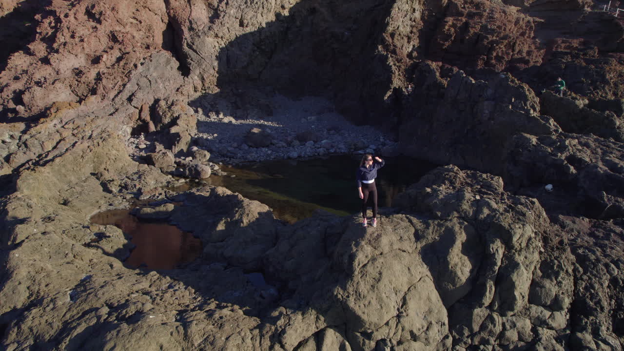 Aerial view of a young woman admiring the landscape in Gran Canaria, Canary Islands, Spain