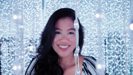 pretty gorgeous young asian filipina woman smiling and laughing in cool fairy lights in 4k slow motion