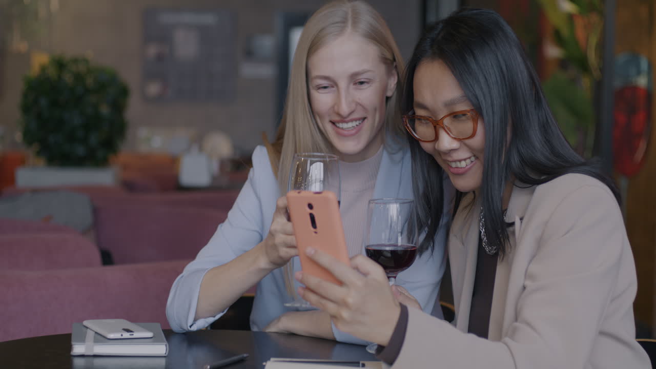 Businesswomen enjoying wine and a conversation in a cafe.
